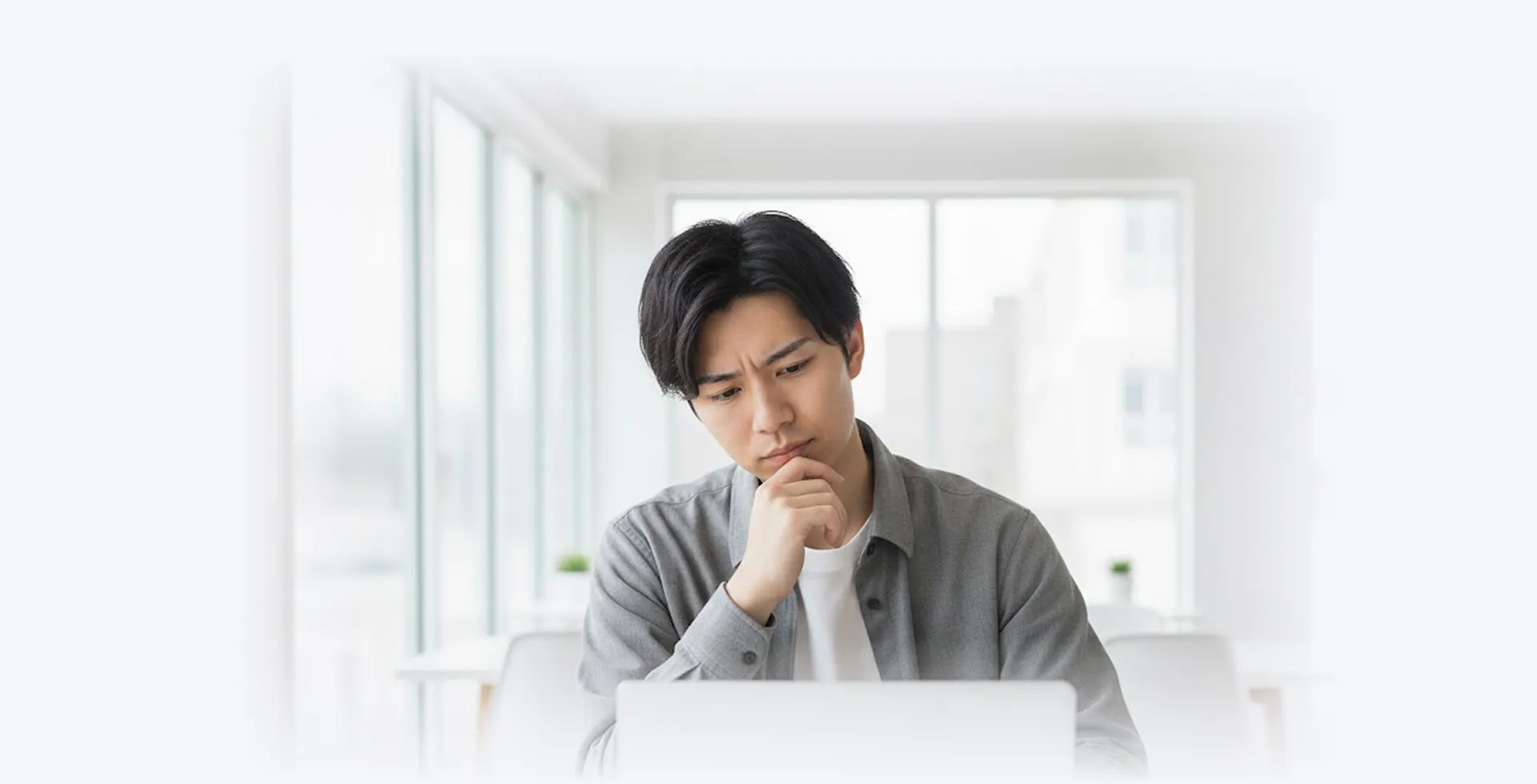 パソコンの前で悩む男性